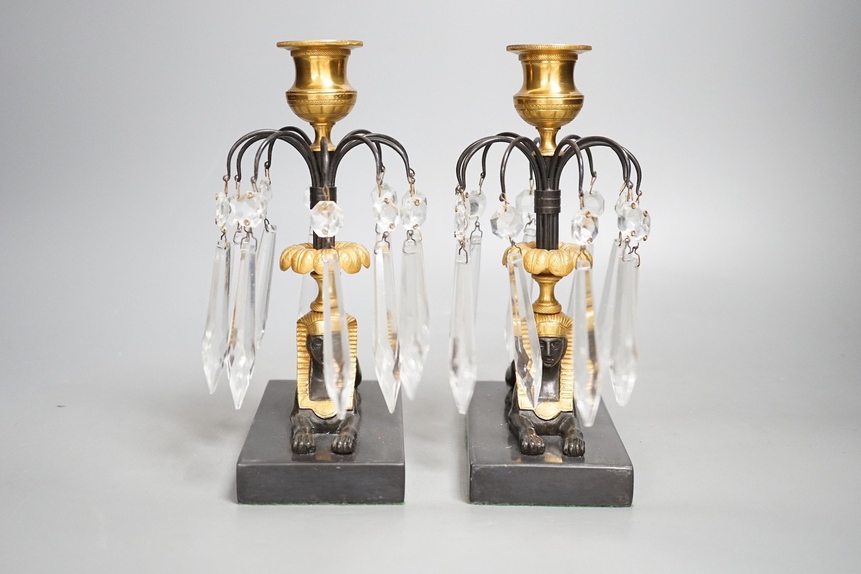 A pair of gilt bronze and glass lustre drop 'sphinx' candlesticks, 21cm